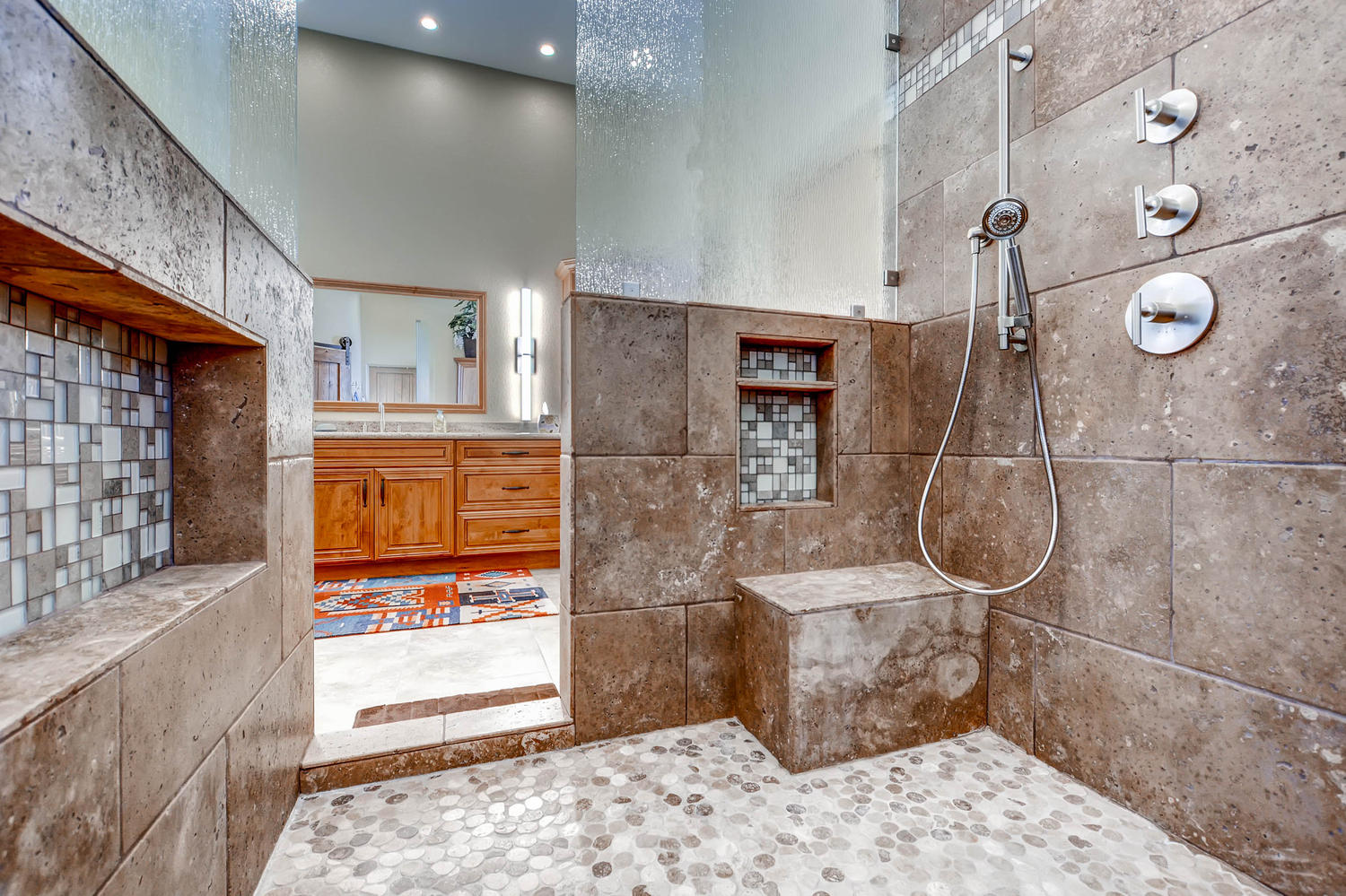 Walk-in stone shower with custom tile